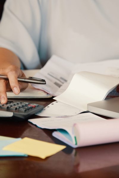 Hands of female entrepreneur working with bills and documents